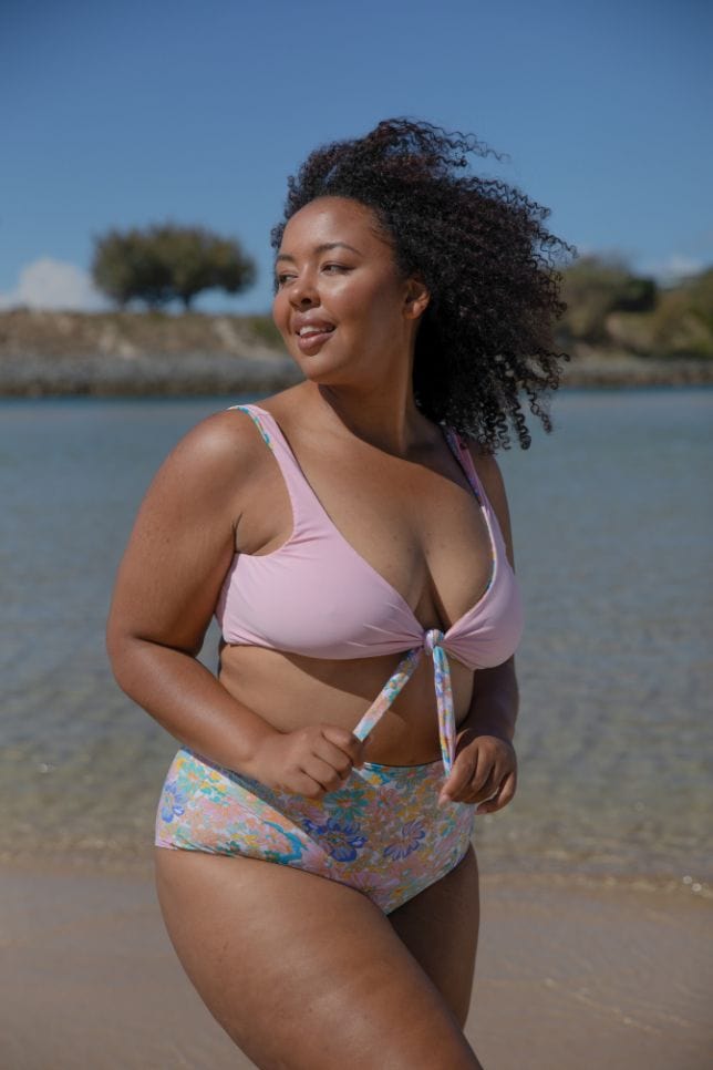 plus size model wearing pink triangle tie front bikini top