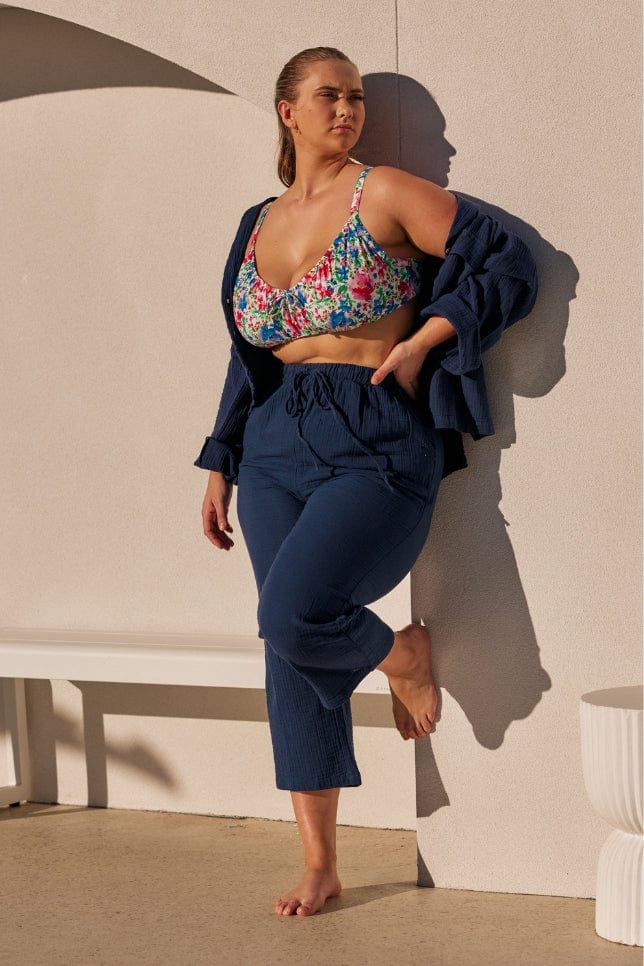 model wearing a navy long crepe set with the buttons undone over a floral bikini