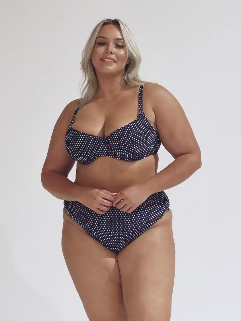 model wearing navy and white dots high rise bikini bottoms with matching top