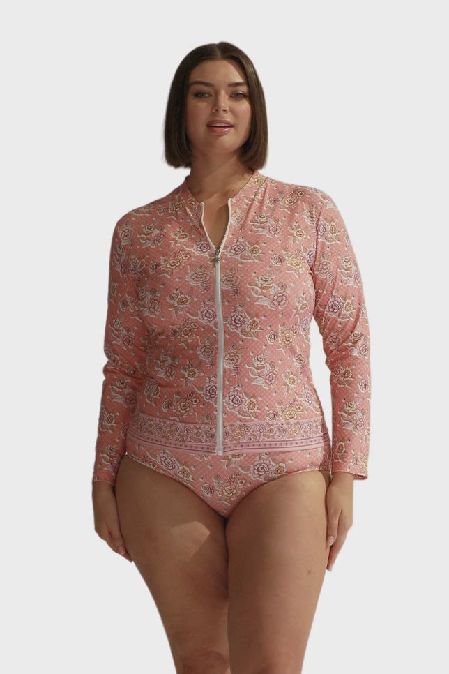 Brunette model wearing pink floral long sleeve rash vest