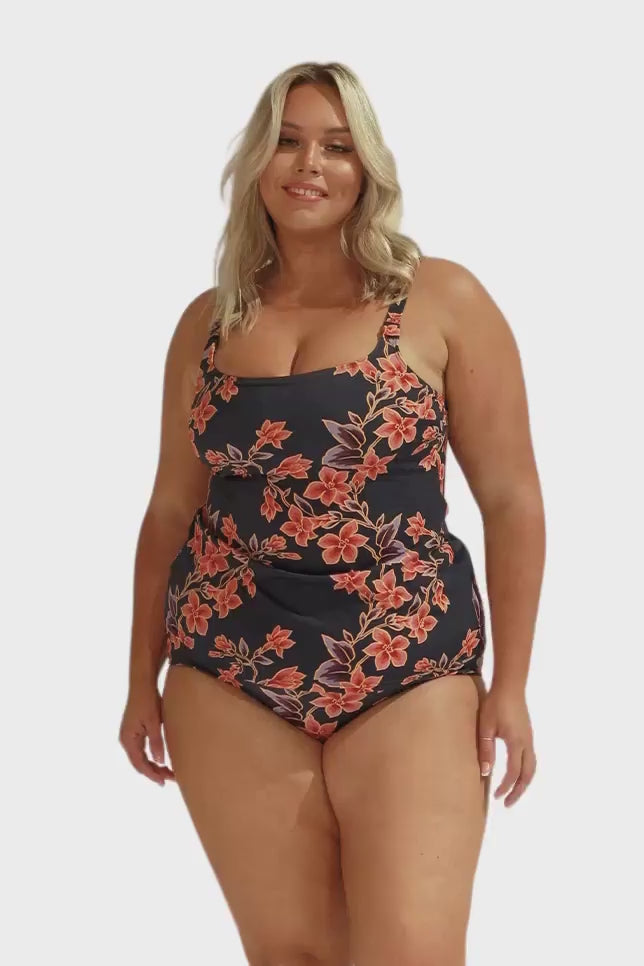 Blonde model wearing tankini top with adjustable straps in navy and orange floral print