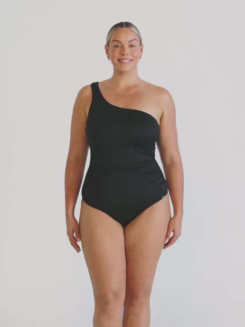 Video of model in studio wearing a one shoulder one piece with textured fabric