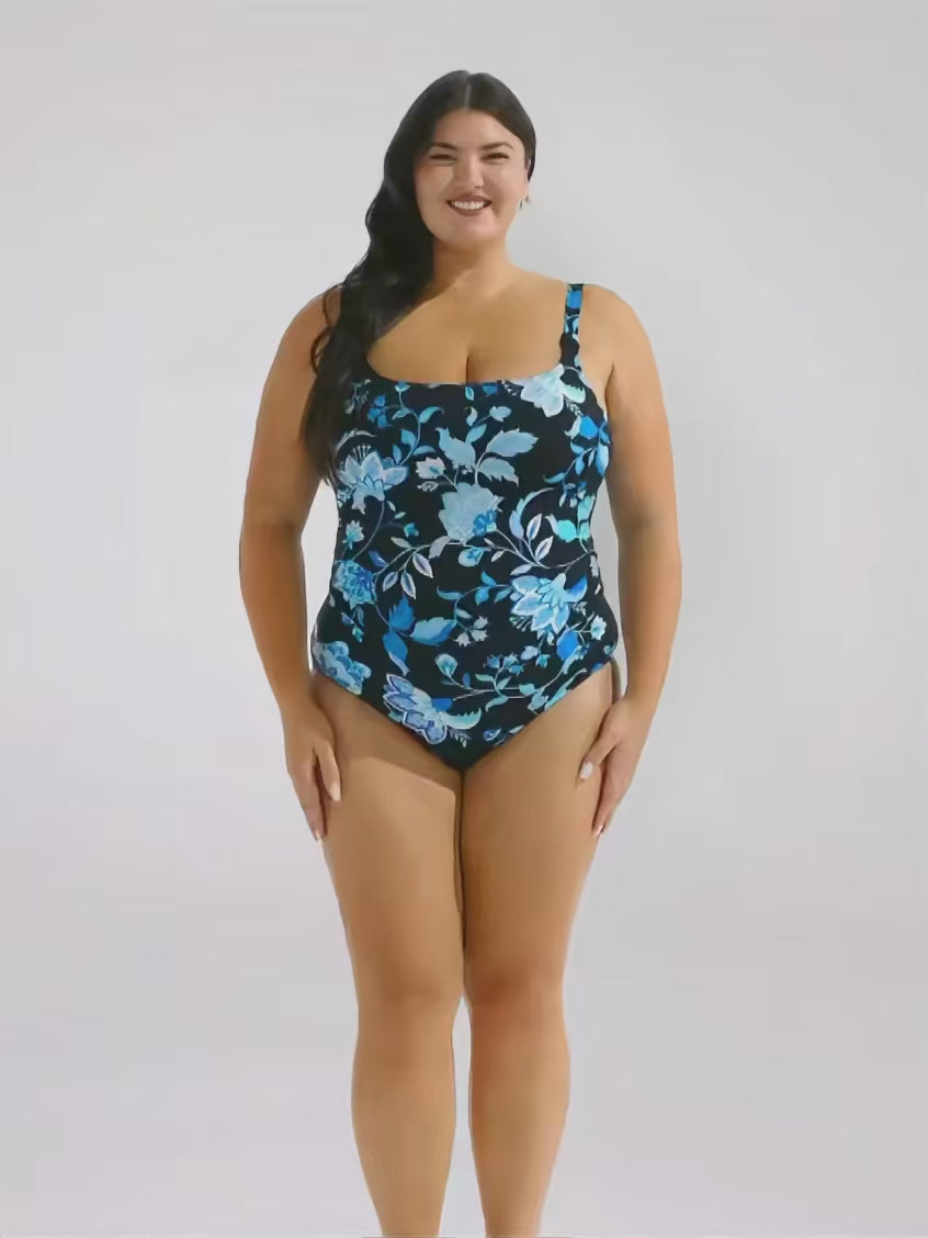 Brunette model in studio wearing tank one piece in blue and black floral 