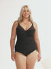 Blonde curvy woman in studio wearing one piece with mesh detail on bust