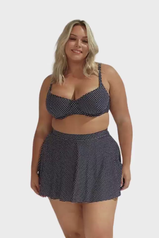 Product video of blonde curve woman wearing navy white skater swim skirt in spots