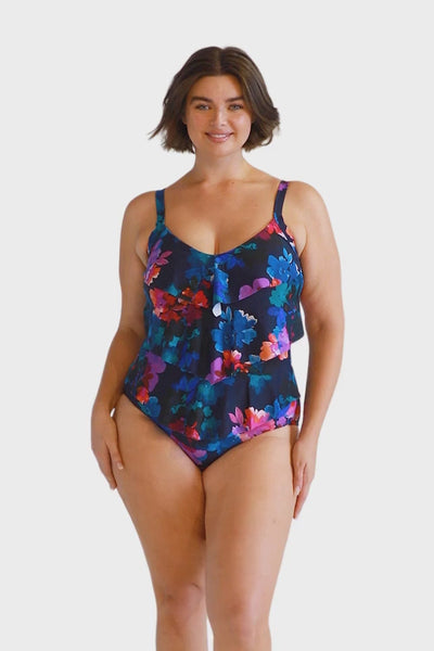 Brunette model wears 3 tier navy floral one piece