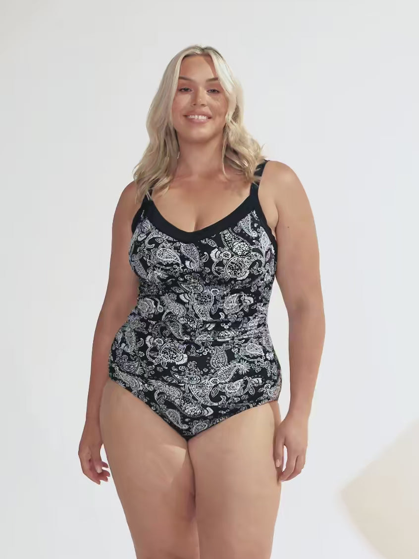Video of model in studio wearing a undewire tankini top in black and white paisley print with ruching on side
