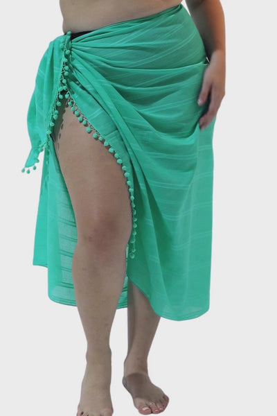 Model wearing jade sarong for curve women with pom pom detailing