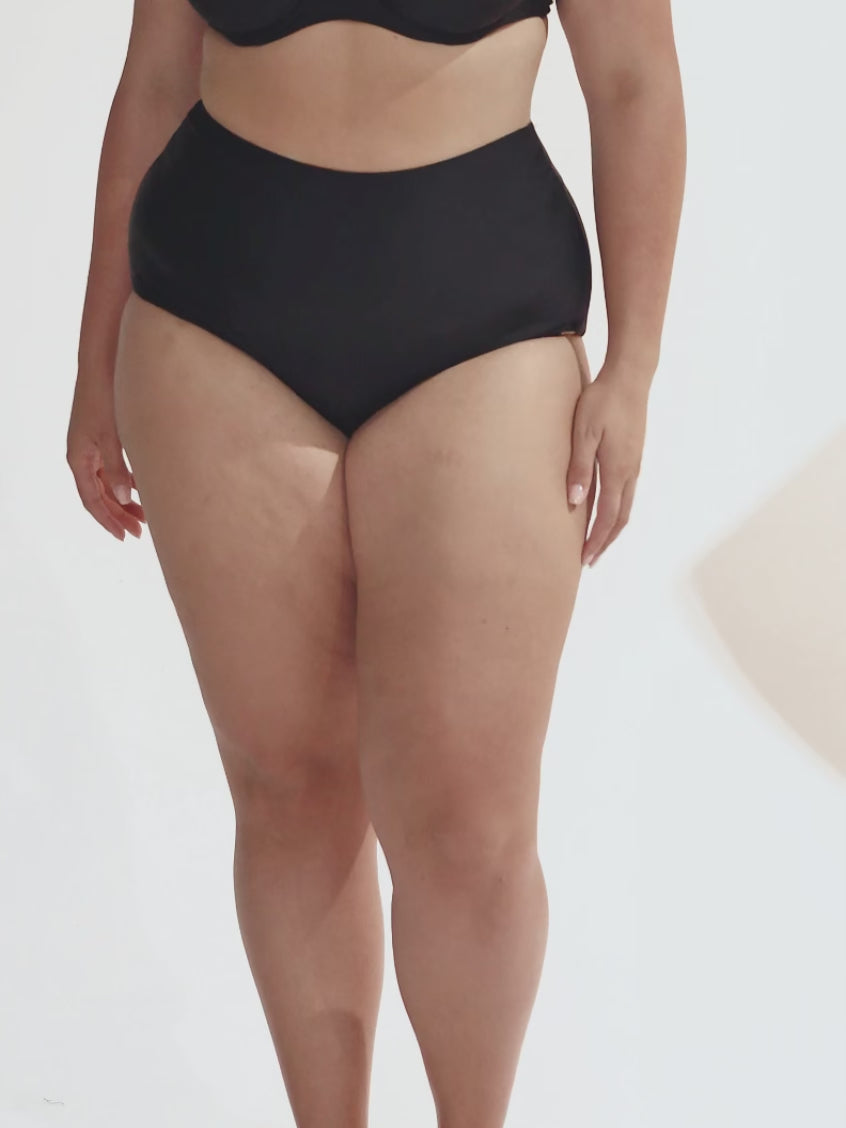 model wearing black high waisted bikini bottoms