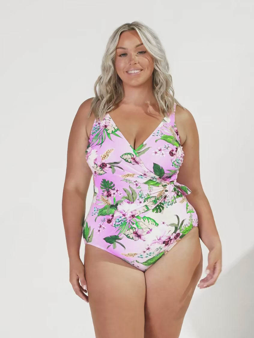Video of plus size blonde model in studio wearing a crossover tie one pice with v neck in floral print