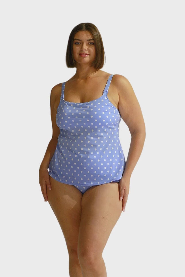 Brunette model wearing chlorine resistant scoop tankini top in blue and white dots for curve women