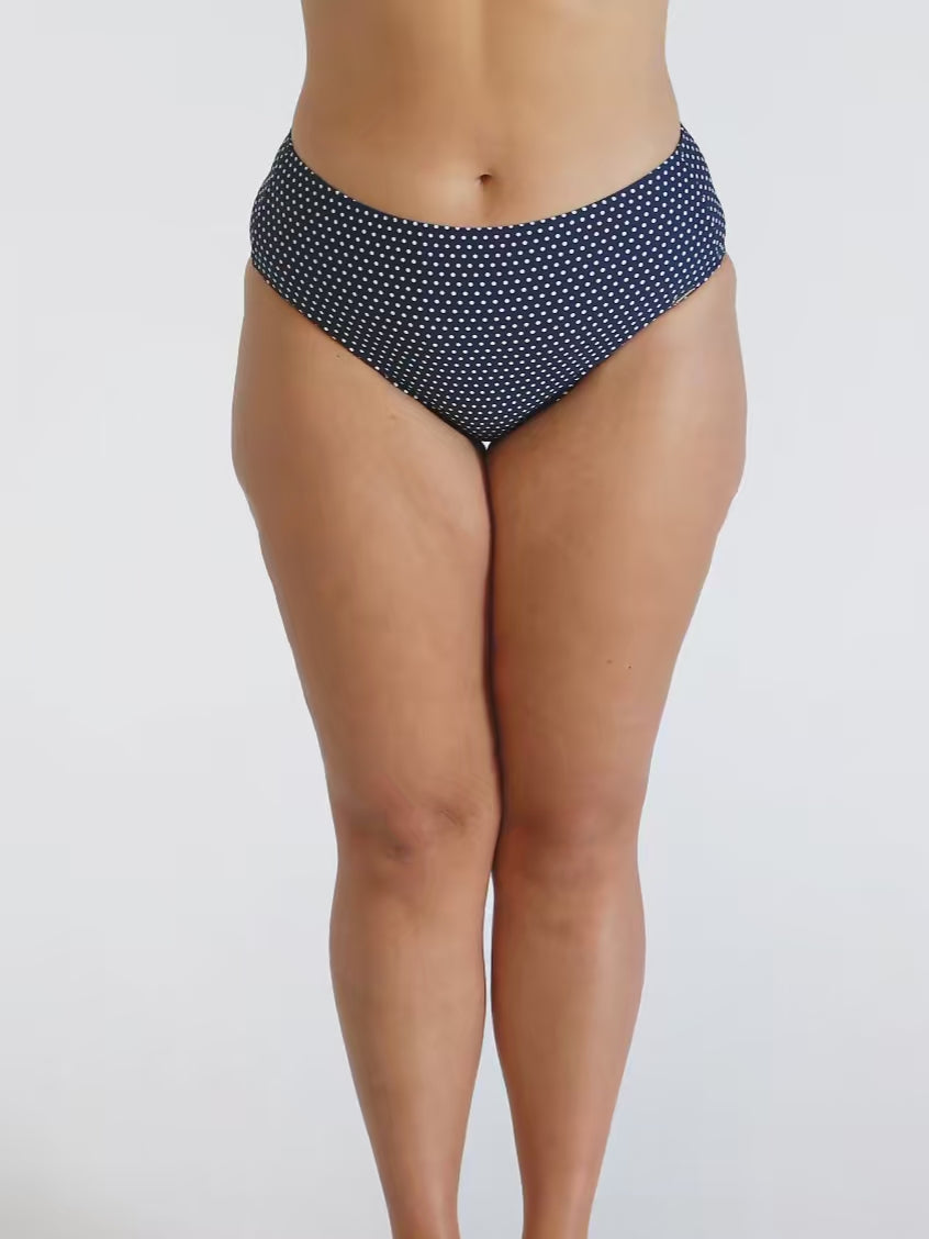 Model in studio wearing curvy navy white dots high rise pant