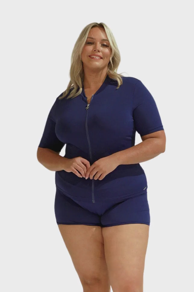 Blonde model wearing chlorine resistant navy short sleeve rash vest and matching pant