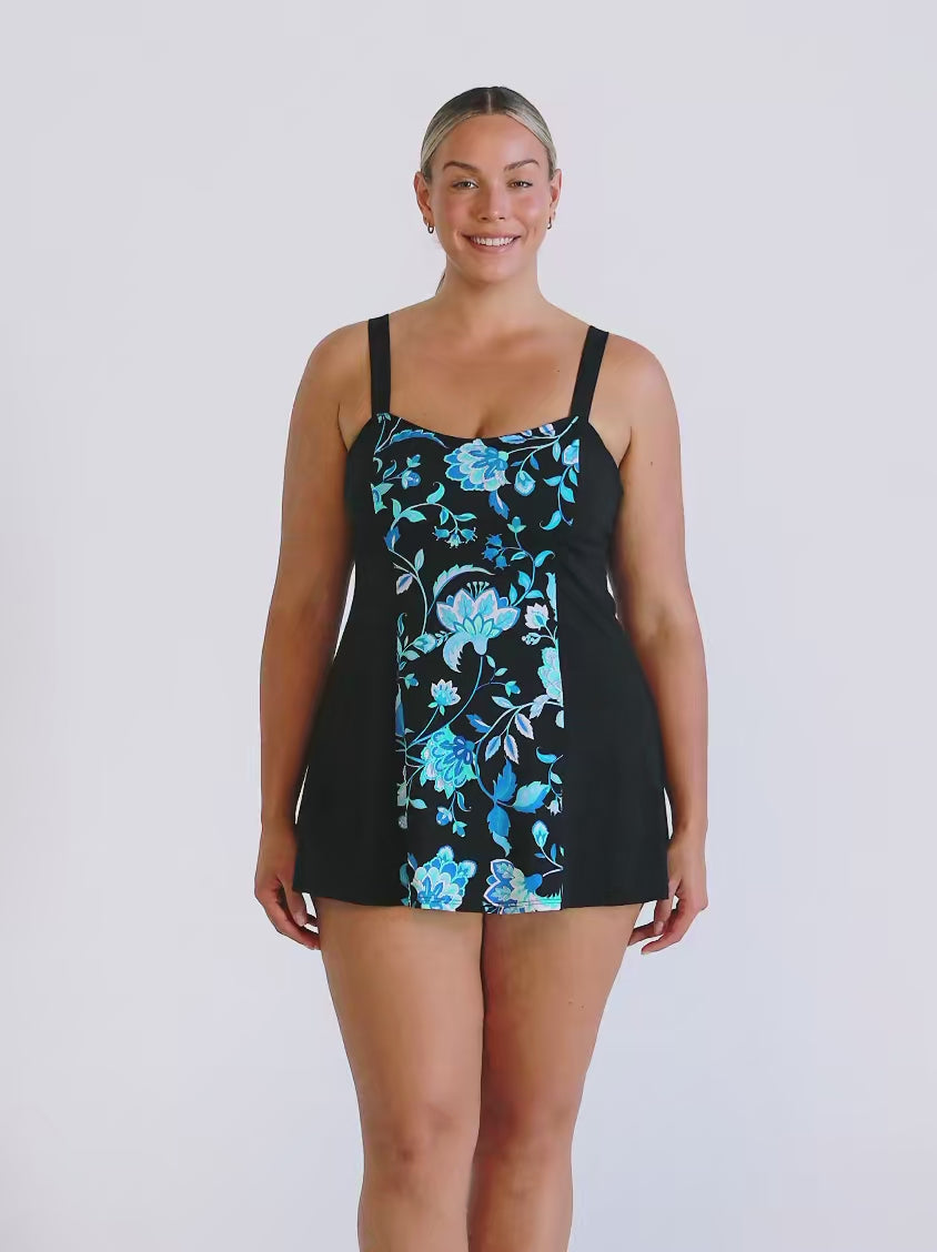 Blonde model in studio wearing a blue and black floral swim dress in chlorine resistant