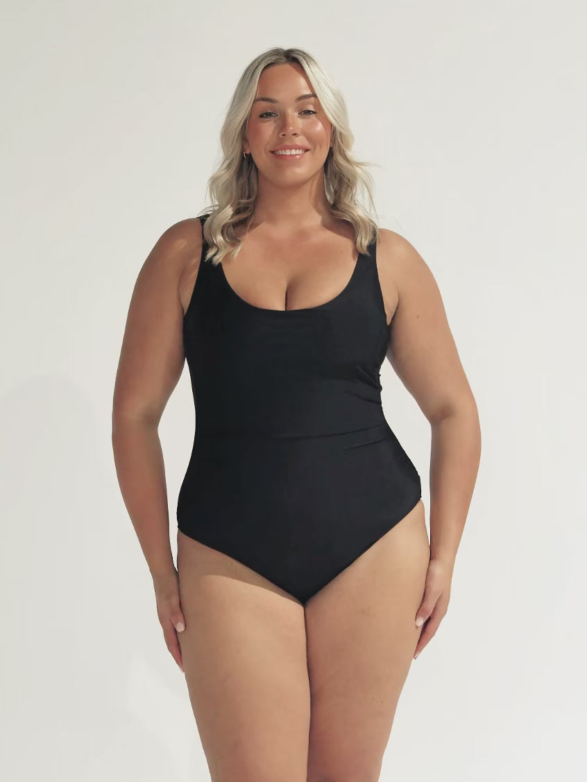 model wearing plain black scooped underwire one piece
