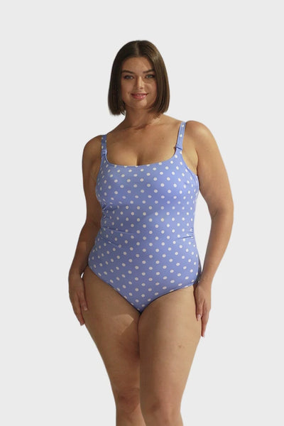 Brunette curve model wearing chlorine resistant scoop one piece in blue and white vintage dots