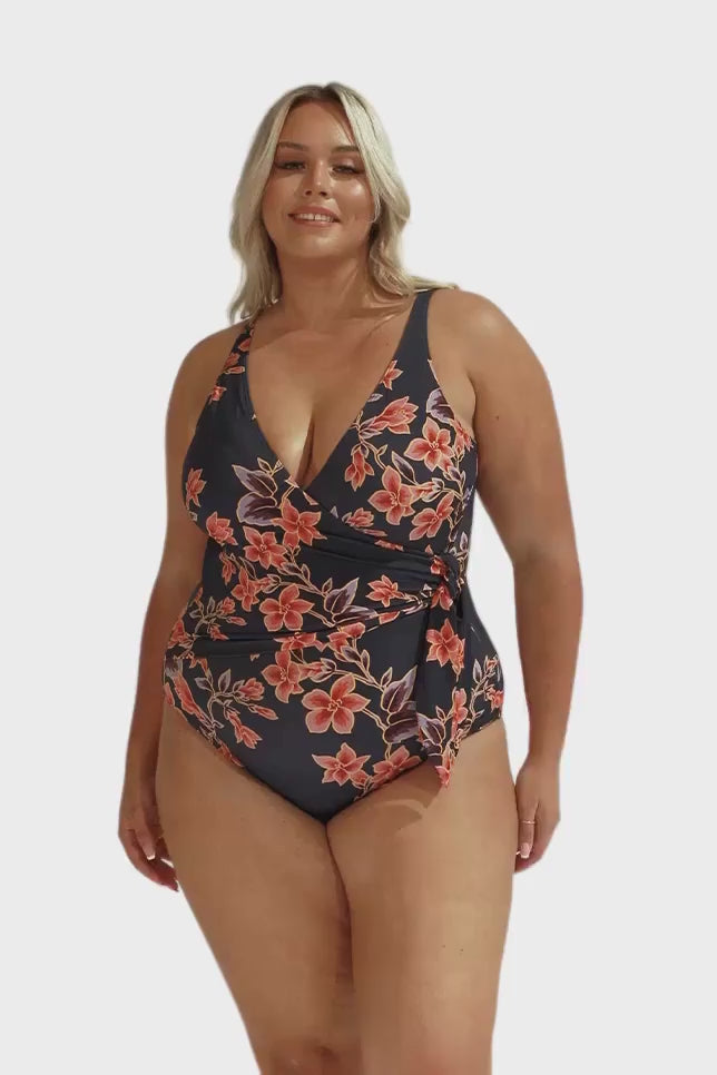 Video of blonde model in studio wearing v neck one piece with side tie detail in floral print for curvy women