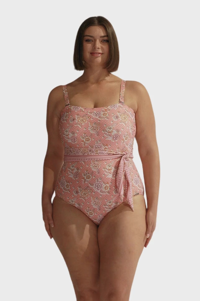 Brunette model wearing blush pink floral underwire bandeau one piece swimsuit