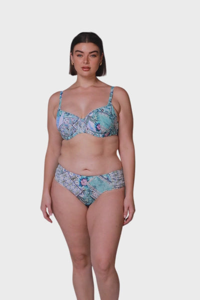 Brunette model wearing blue side ruched mid rise bikini bottoms