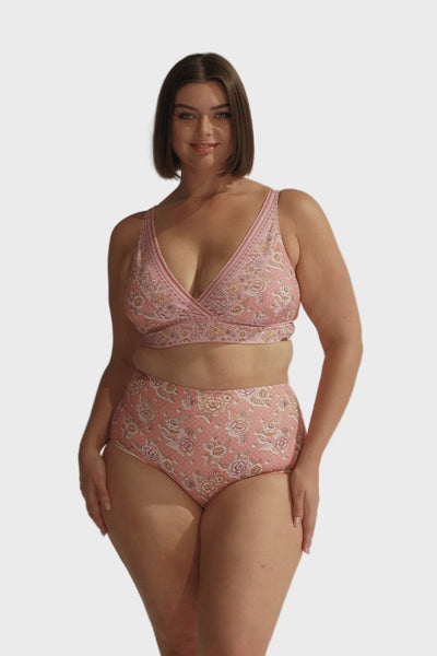 Brunette model wearing high waisted pink floral swim bottoms
