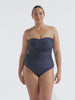 model wearing navy polka dot women's strapless swimsuit