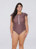 Dark head model in studio wearing a chocolate polkadot frill sleeve one piece with zip front