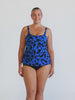 Blonde model in studio wearing blue and black tank tankini top for chlorine pool