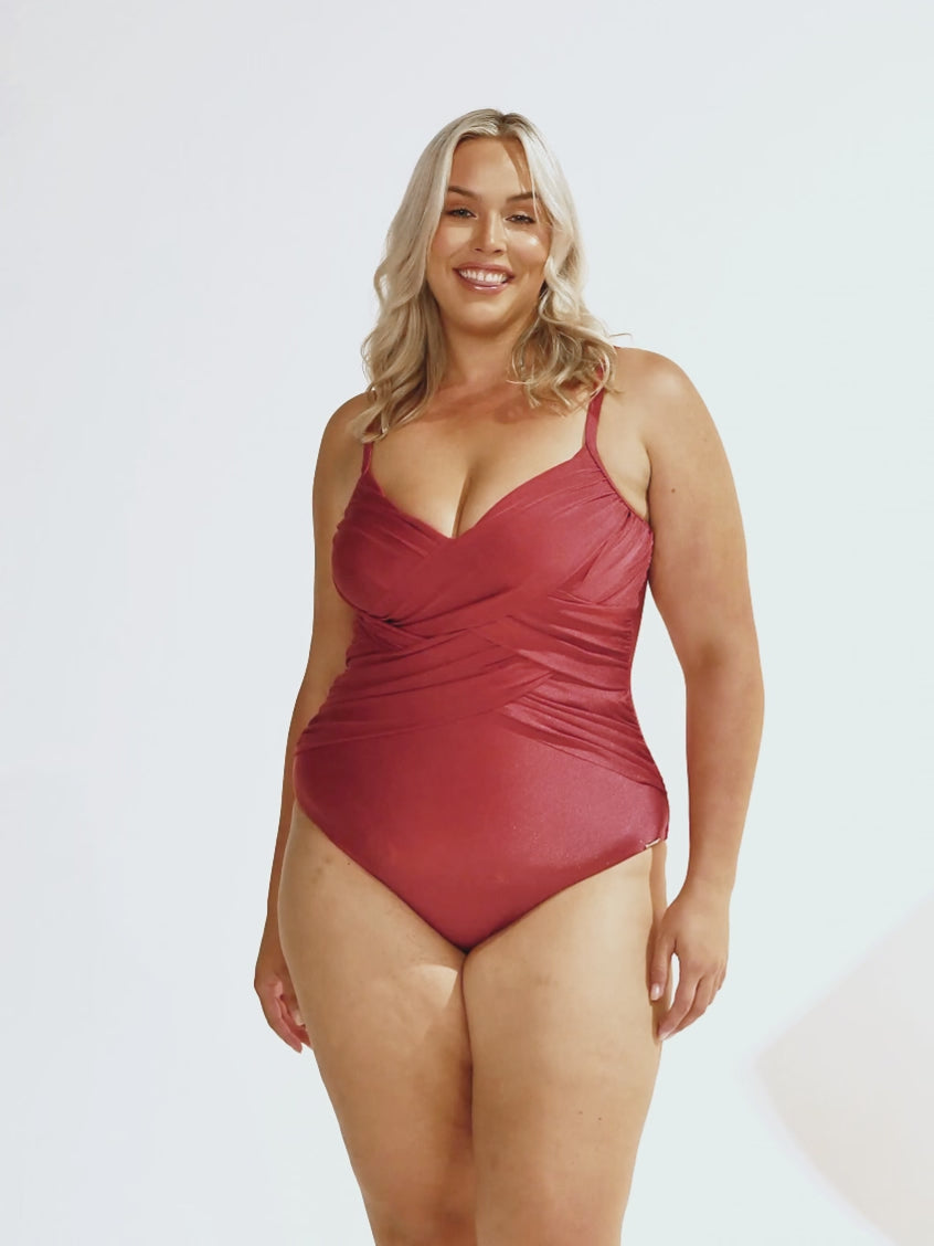 Video of blonde woman in studio wearing a criss cross metallic one piece