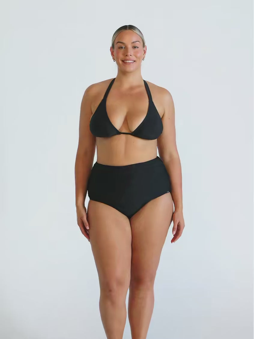 Blonde woman in studio wearing a black halter bikini top 