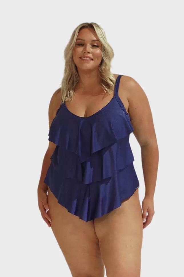 Video of model in studio wearing navy blue ruffled tankini top