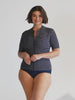 model wearing navy and white dots zip front rash vest with navy bottoms