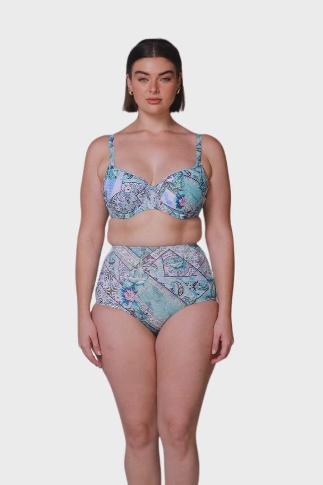 Brunette model wears blue patchwork high waisted swim pants