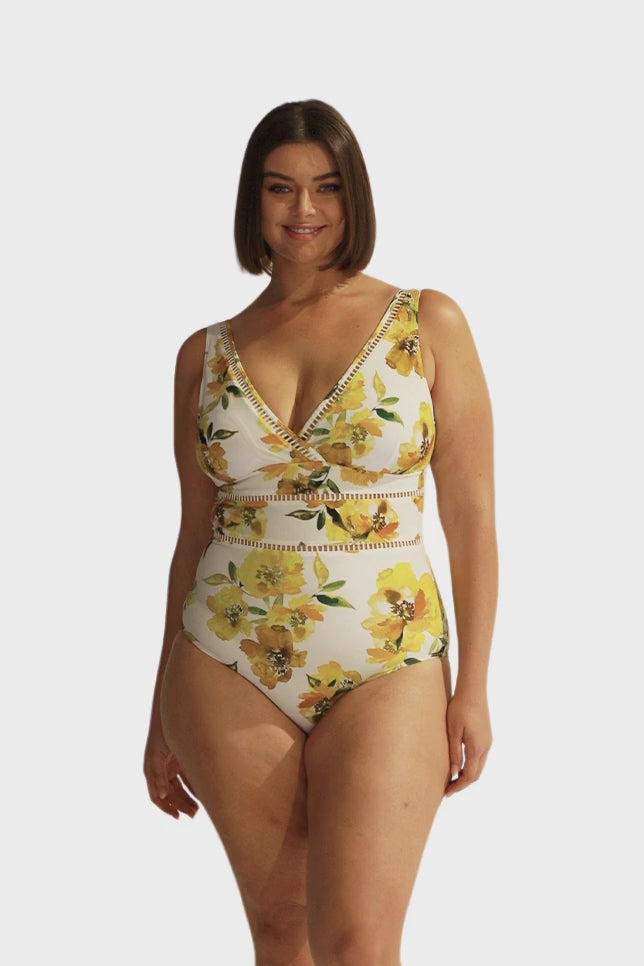 Brunette curve model wearing yellow floral v neck one piece with lace trim