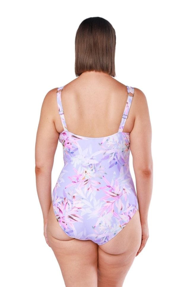 Back of brunette model wearing purple and pink tropical one piece with adjustable straps