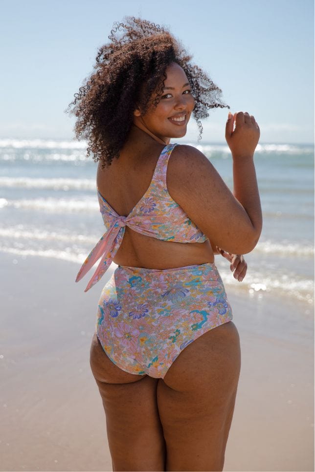 pink floral tie back bikini top on plus size model at the beach