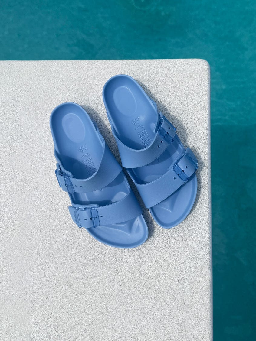 Blue sandals on a diving board over pool