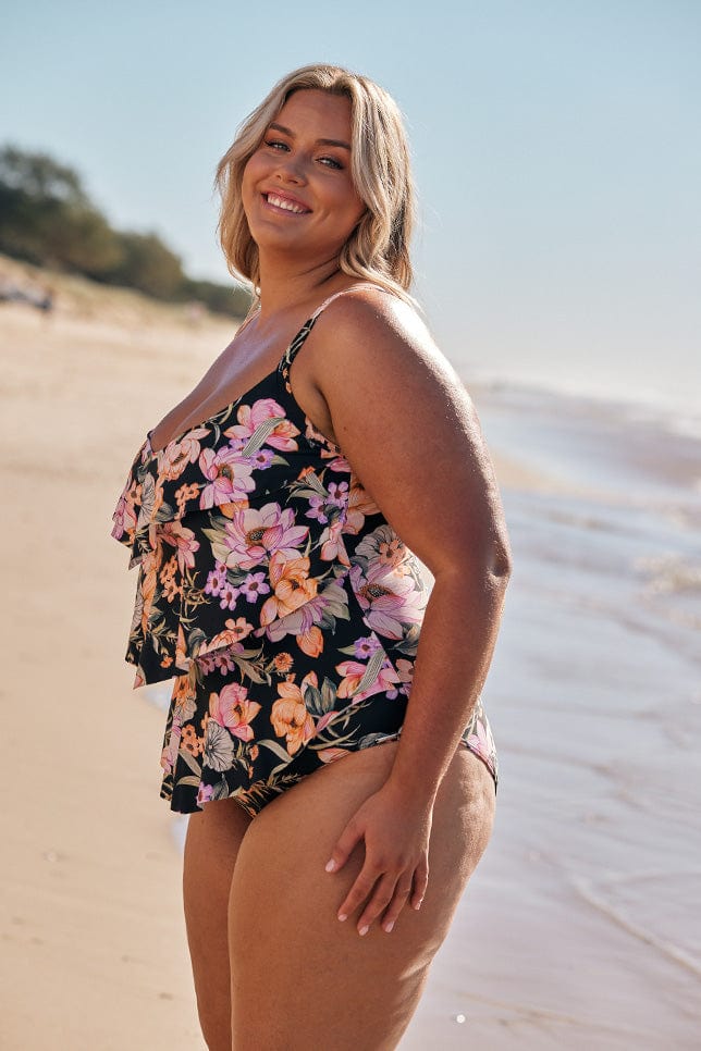 Blonde model wearing black floral 3 tier one piece