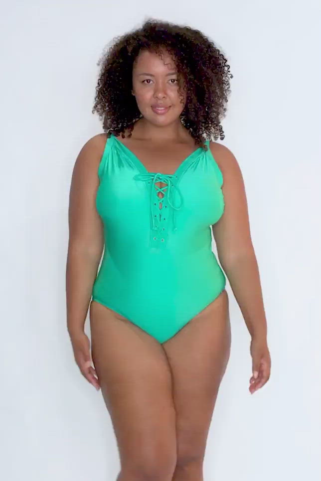 video of model wearing a green coloured one piece with a tie front