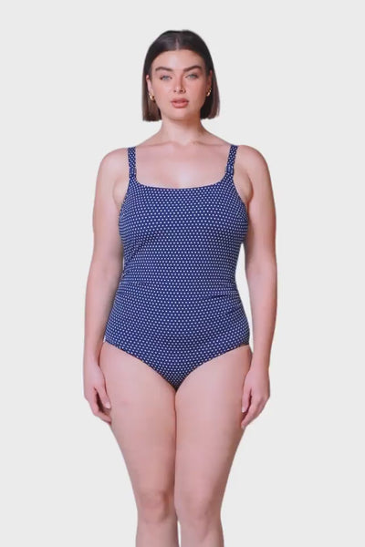 brunette plus size model wears navy and white dots tank tankini top with low scoop back