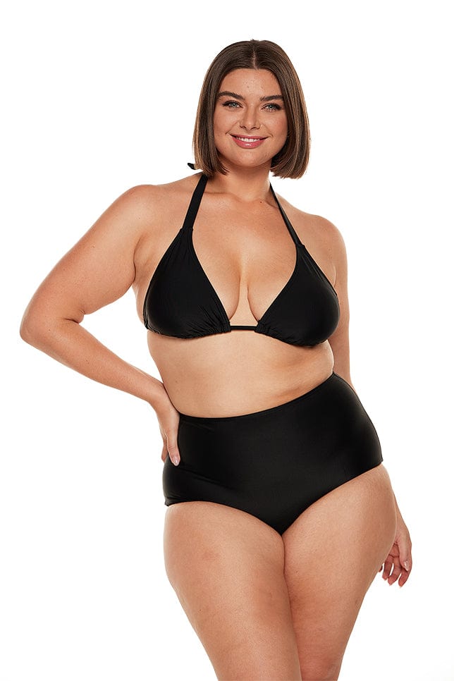 Brunette plus size model wears black halter neck bikini top with high waisted pant