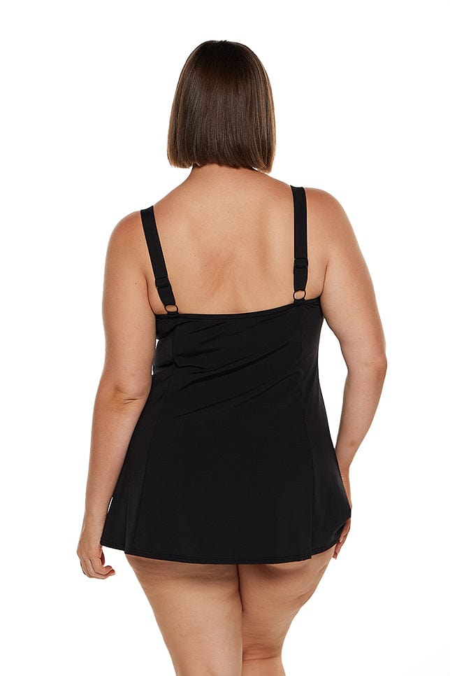 brunette plus size model wears black chlorine resistant wide strap swim dress with no pant