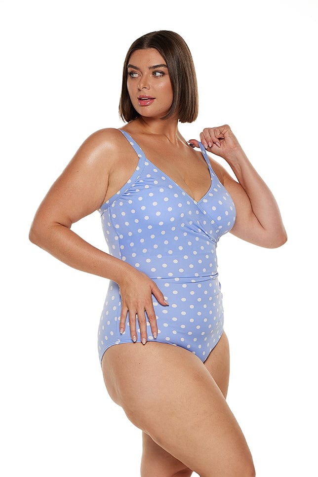 Brunette women wears blue polkadot chlorine resistant v neck one piece