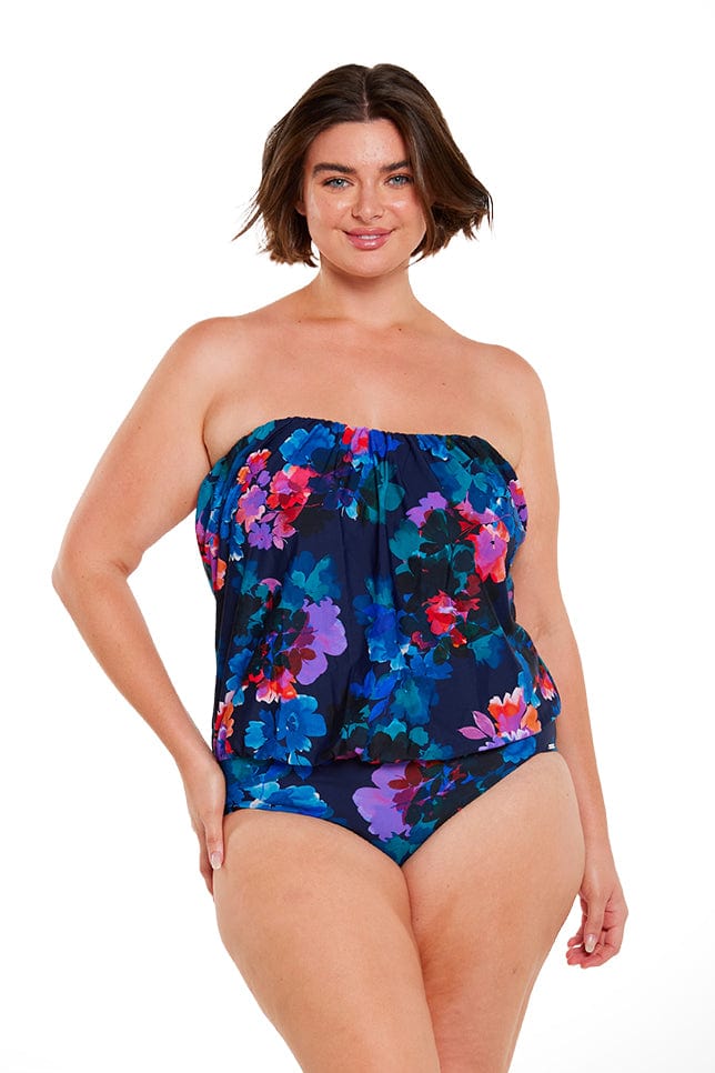 brunette model wears strapless bandeau one piece navy blue floral