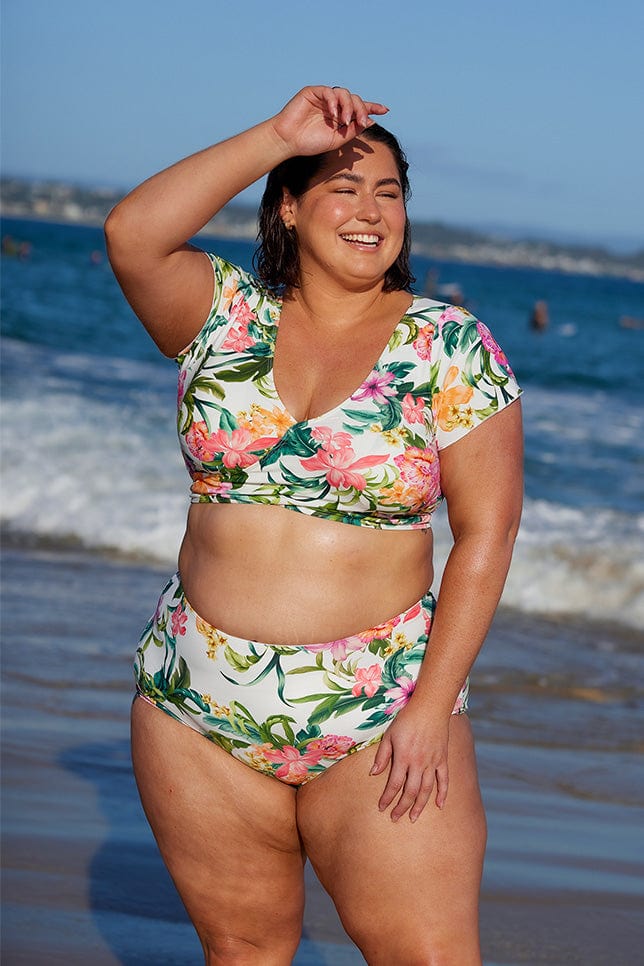 Brunette model wearing tropical white swim bikini bottoms