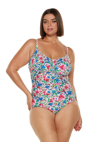 Brunette model wears ruched underwire one piece in bright floral print