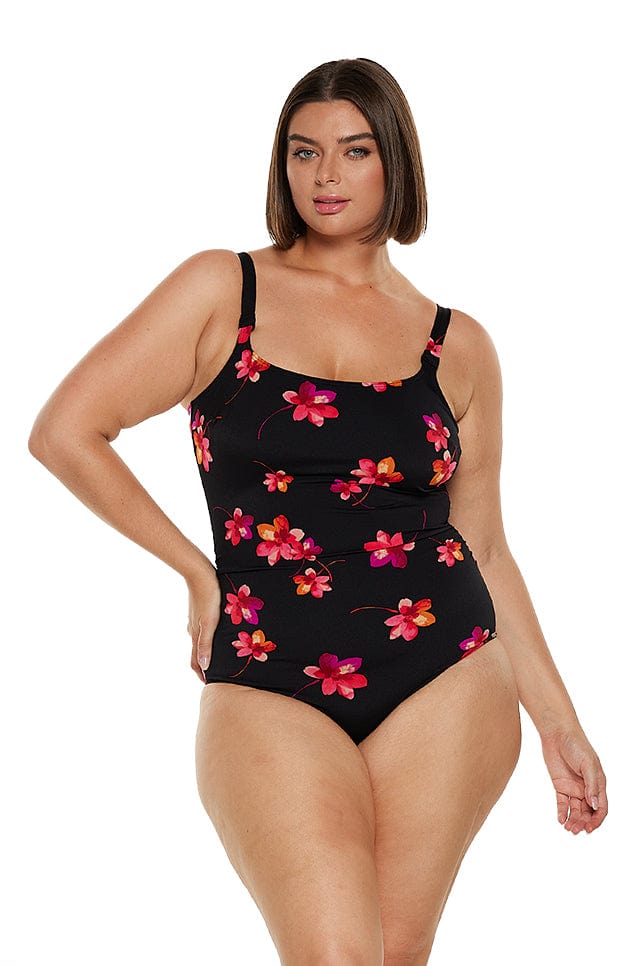 Brunette model wears chlorine resistant scoop one piece with pink and red flower details