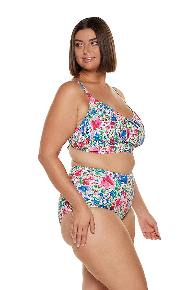 Side profile of model in studio wearing curvy bright coloured floral bikini pant