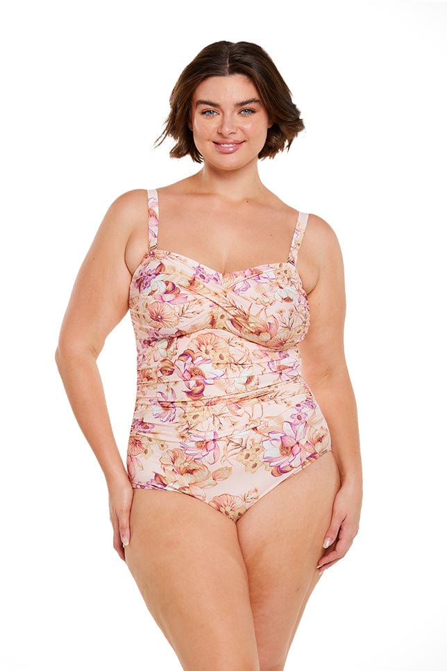 Brunette model wears floral twist front bandeau one piece with removable straps