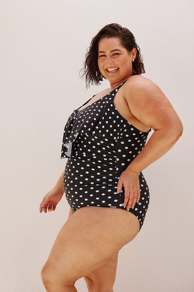 Curve model wearing black and white dots supportive one piece with adjustable straps
