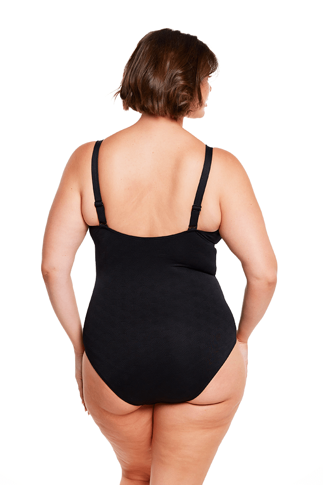 brunette model wears black supportive one piece swimwear australia